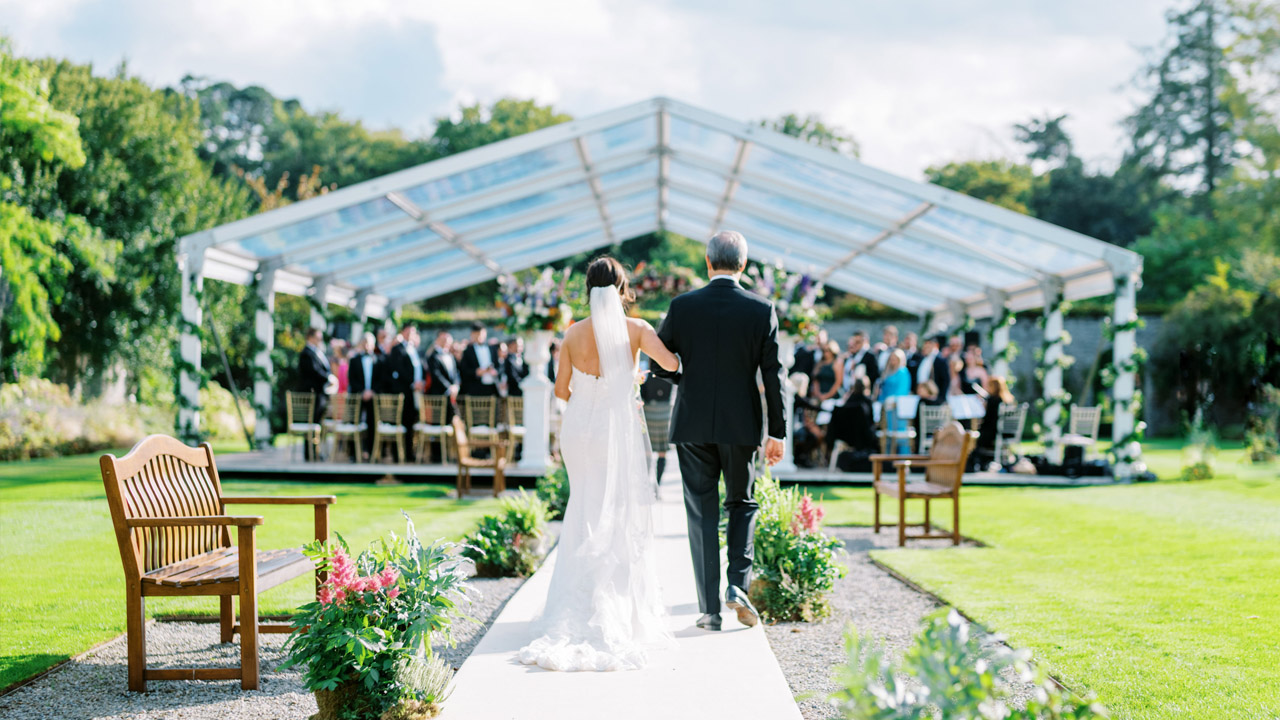 Bride and Father of the Bride walk down the aisle in the Walled Gardens at Adare Manor