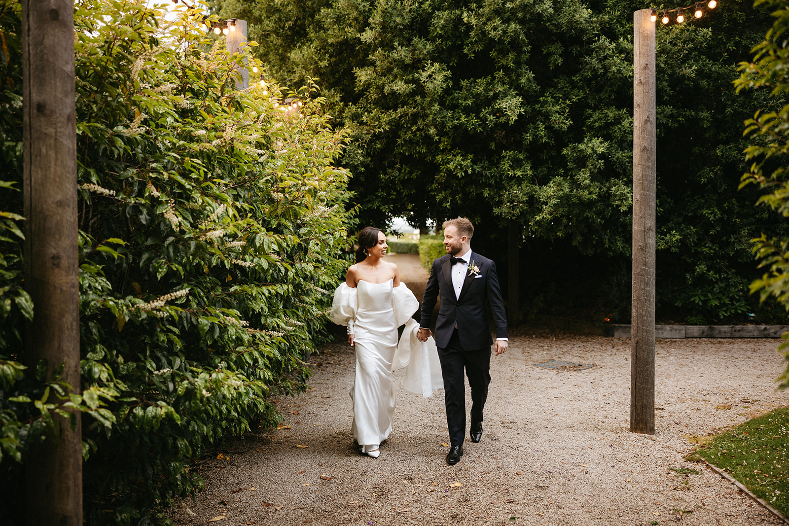 Bride and Groom, hand-in-hand, walking through the grounds of Tinakilly House on their wedding day