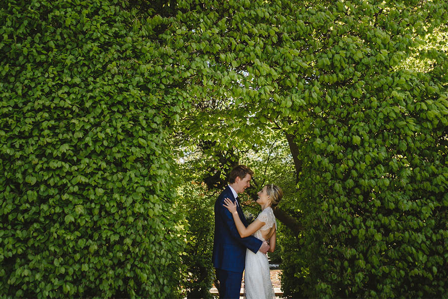 Bride and Groom embracing in the maze garden at Killruddery House and Gardens
